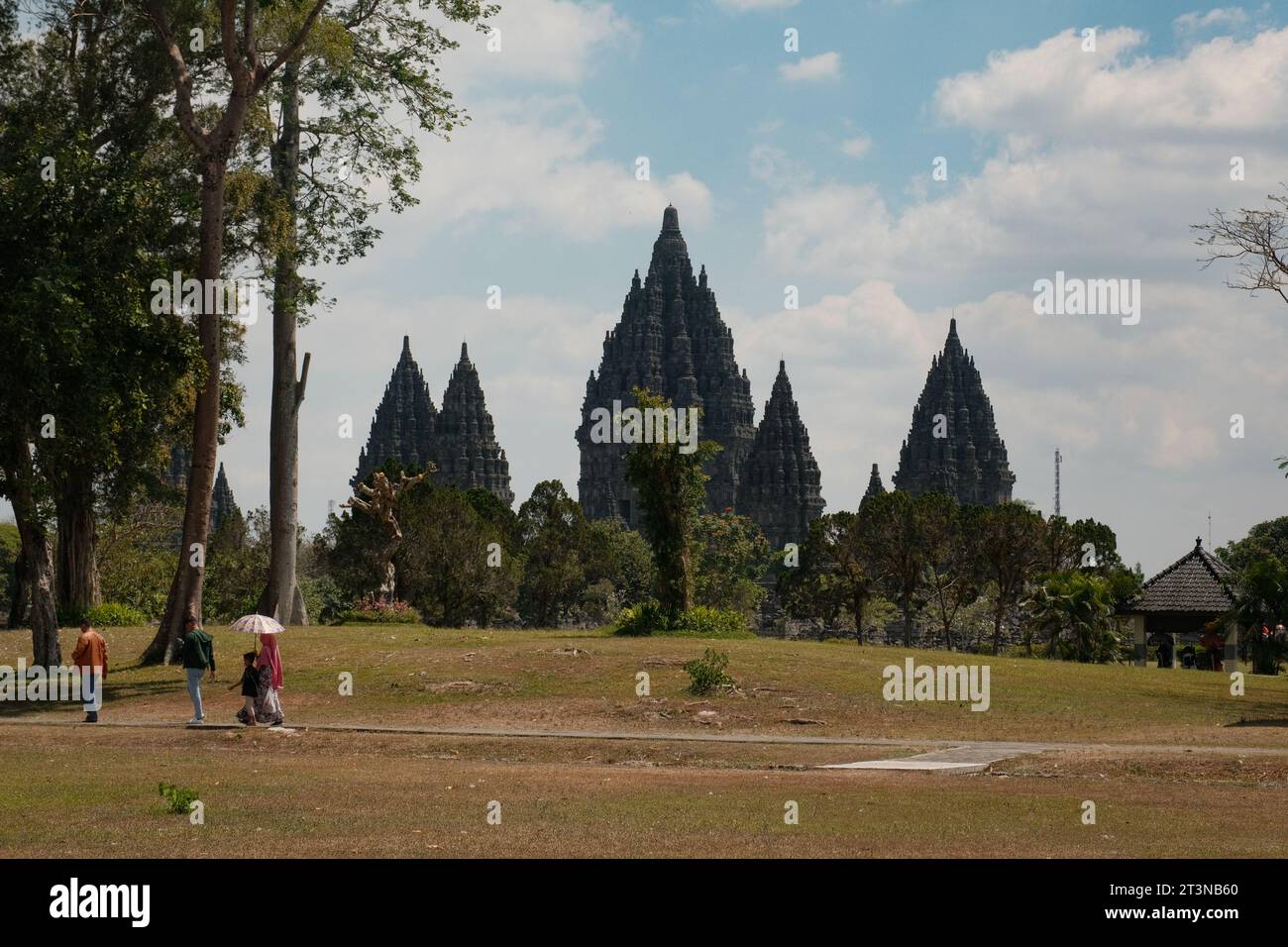 Bewundern Sie die Pracht des Prambanan-Tempels in Yogyakarta, von außen beobachtet, wo eine Familie einen gemütlichen Spaziergang macht. Stockfoto