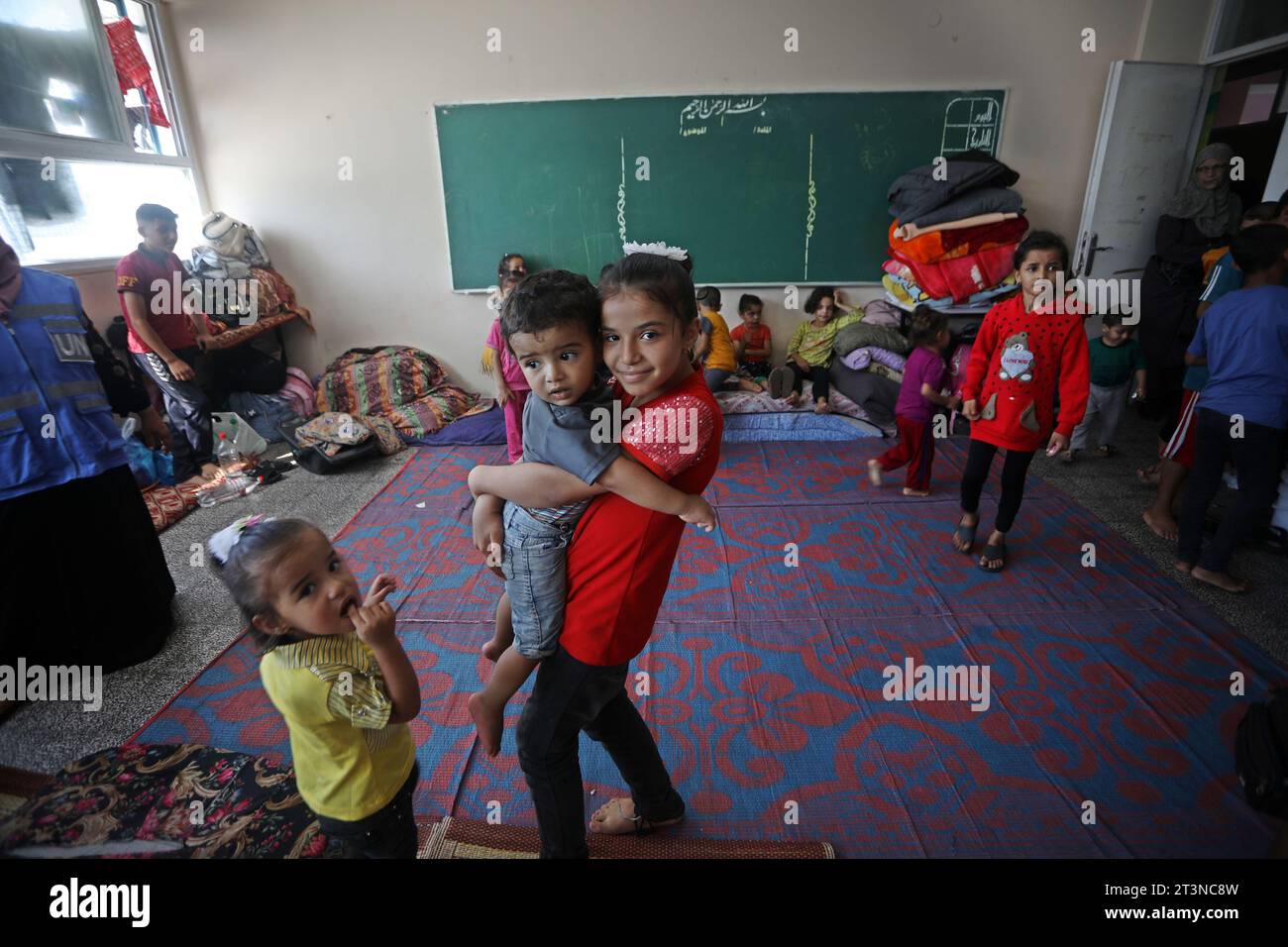 Palästinensische Menschen, einschließlich Kinder, die vor israelischen Angriffen fliehen, finden am 20. Oktober 2023 in Rafah im südlichen Gazastreifen Zuflucht in einer Schule, die dem Hilfswerk der Vereinten Nationen für Palästinaflüchtlinge im Nahen Osten (UNRWA) angehört. Die israelischen Luftangriffe werden am 20. Tag in Gaza fortgesetzt. Seit Beginn der israelischen Luftangriffe wurden in Gaza mehr als 187.000 Menschen vertrieben. Die UN-Agentur bestätigte, dass die Unterkünfte im Gazastreifen überfüllt sind und Trinkwasser sehr begrenzt ist. Foto: Ismael Mohamad/UPI. Stockfoto