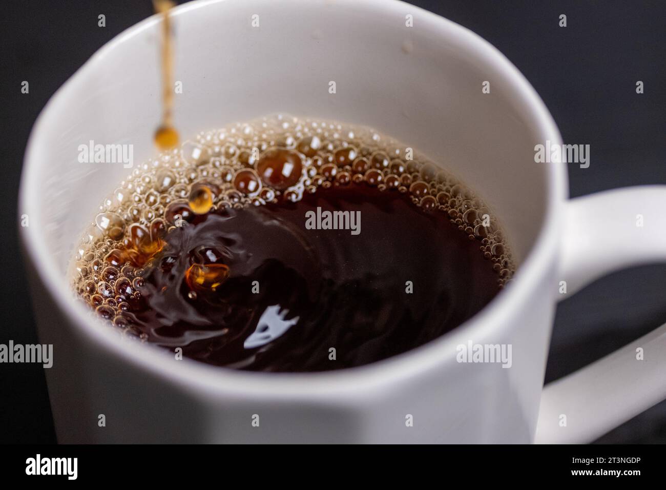 In Makroaufnahme Kaffee in ein Glas gießen Stockfoto