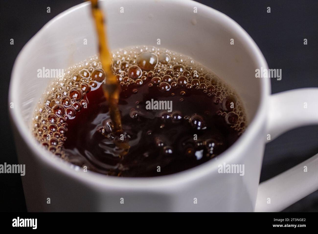 In Makroaufnahme Kaffee in ein Glas gießen Stockfoto