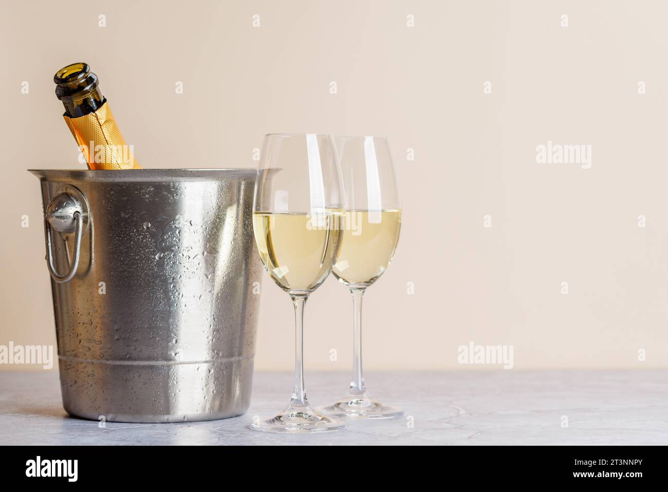 Zwei Sektgläser und eine Flasche im Eiskübel. Weihnachtsgrußkarte mit Kopierraum Stockfoto