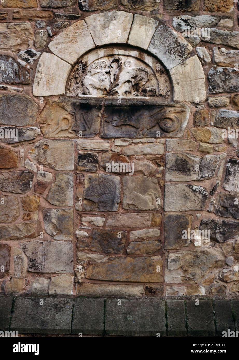 Geschnitztes Tympanon und Sturz der blockierten C11th W-Tür der St. John the Baptist's Church, Ault Hucknall, Derbyshire, England, Großbritannien. Obere L: St. Margaret. Stockfoto