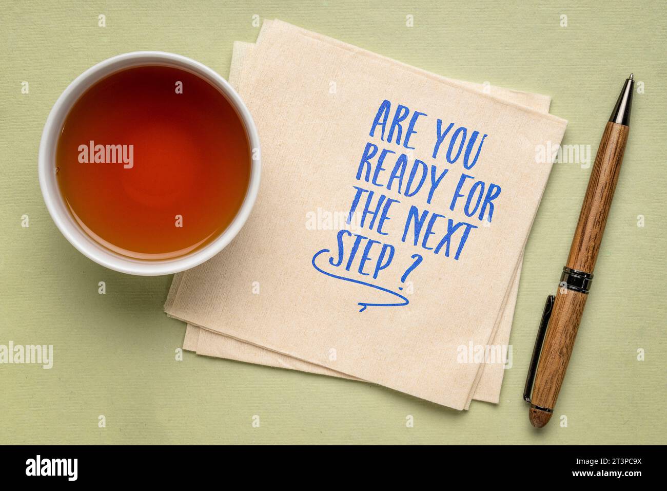 Sind Sie bereit für den nächsten Schritt? Selbstbesinnungsfrage auf einer Serviette mit Tee. Persönliche Entwicklung oder Karrierekonzept. Stockfoto