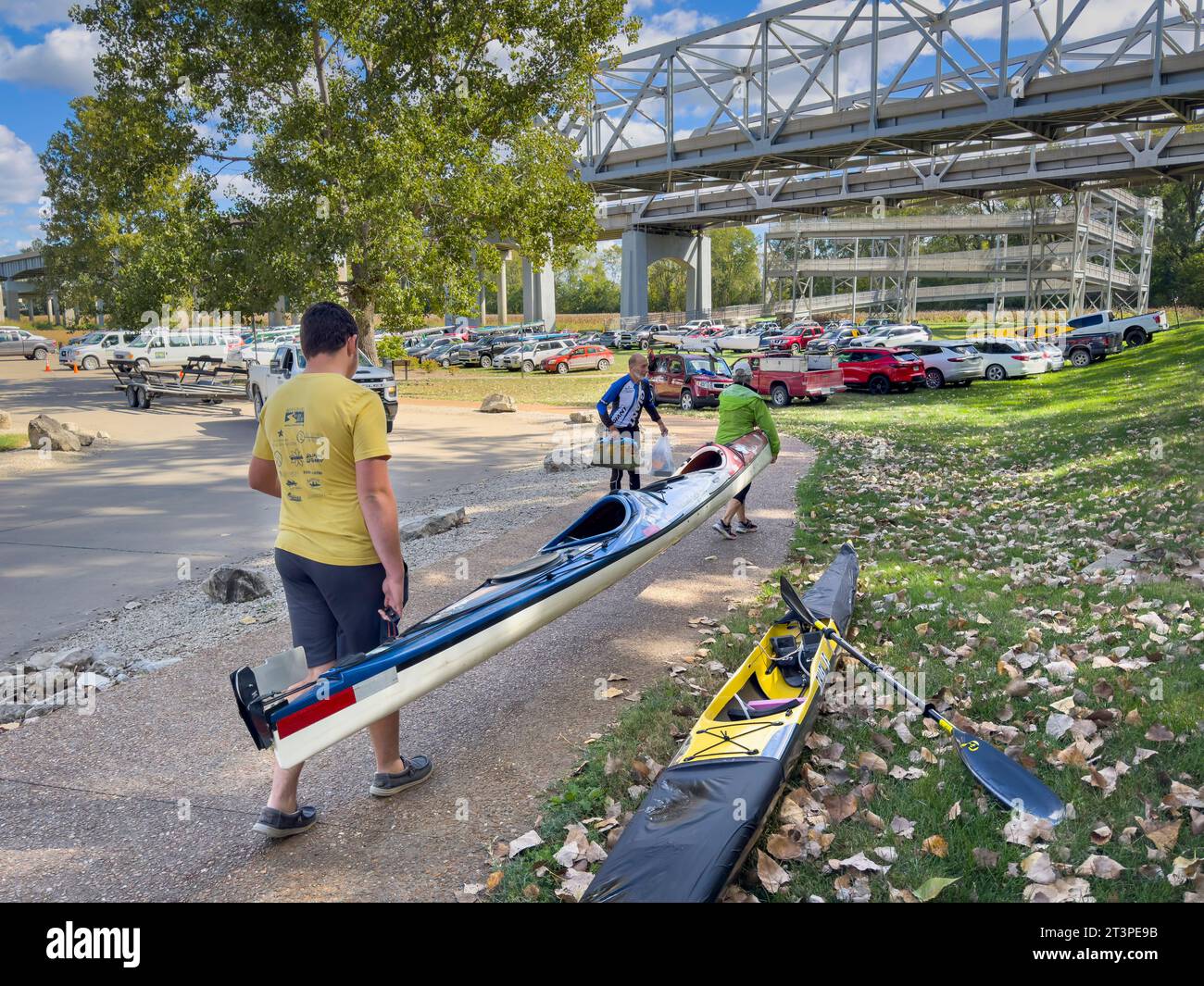 Jefferson City, MO, USA – 7. Oktober 2023: Paddler bringen ihr Seekajak nach einem Paddelrennen auf dem Missouri River zu einem Parkplatz. Stockfoto