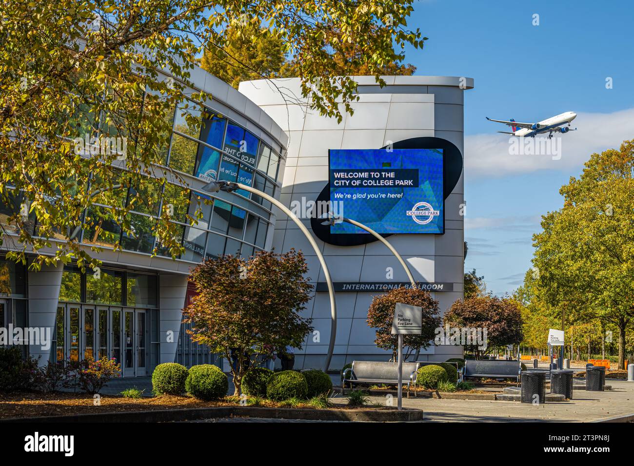 Georgia International Convention Center mit Delta Air Lines Jet On-Anflug zur Landung am nahe gelegenen Atlanta International Airport. (USA) Stockfoto