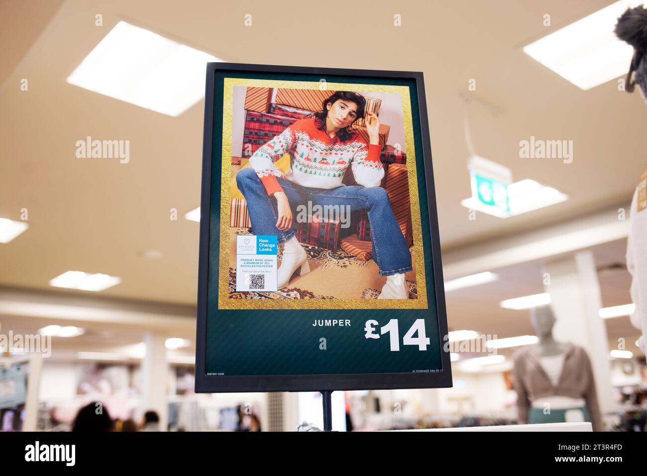 Primark Weihnachtspullover im Geschäft Werbetoster mit androgyn aussehendem Model in männlicher Pose Stockfoto