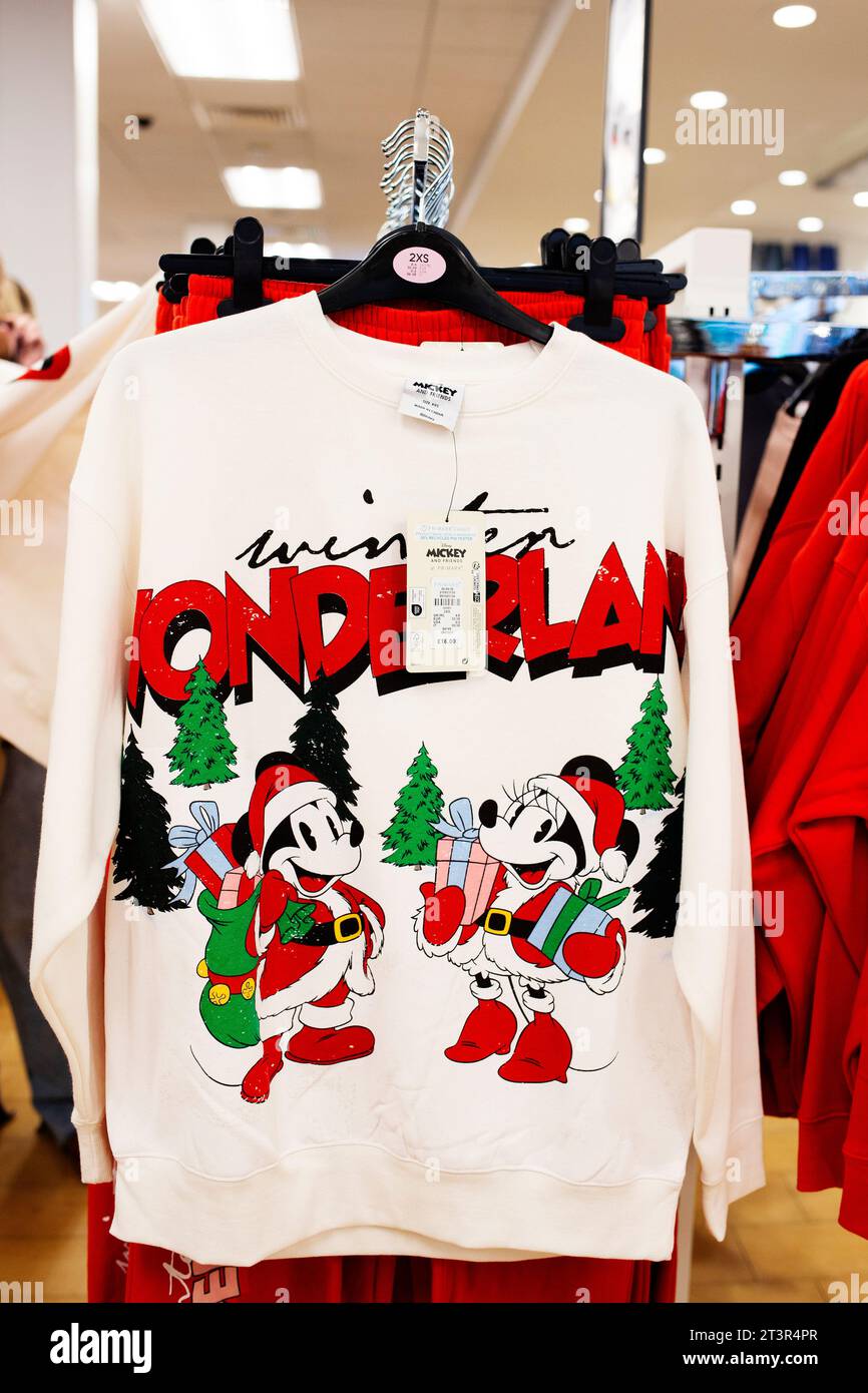 Primark 2023 Christmas Pullover Kollektion - Disney Winter Wonderland Illustrated Design in rot und grün auf Creme Stockfoto