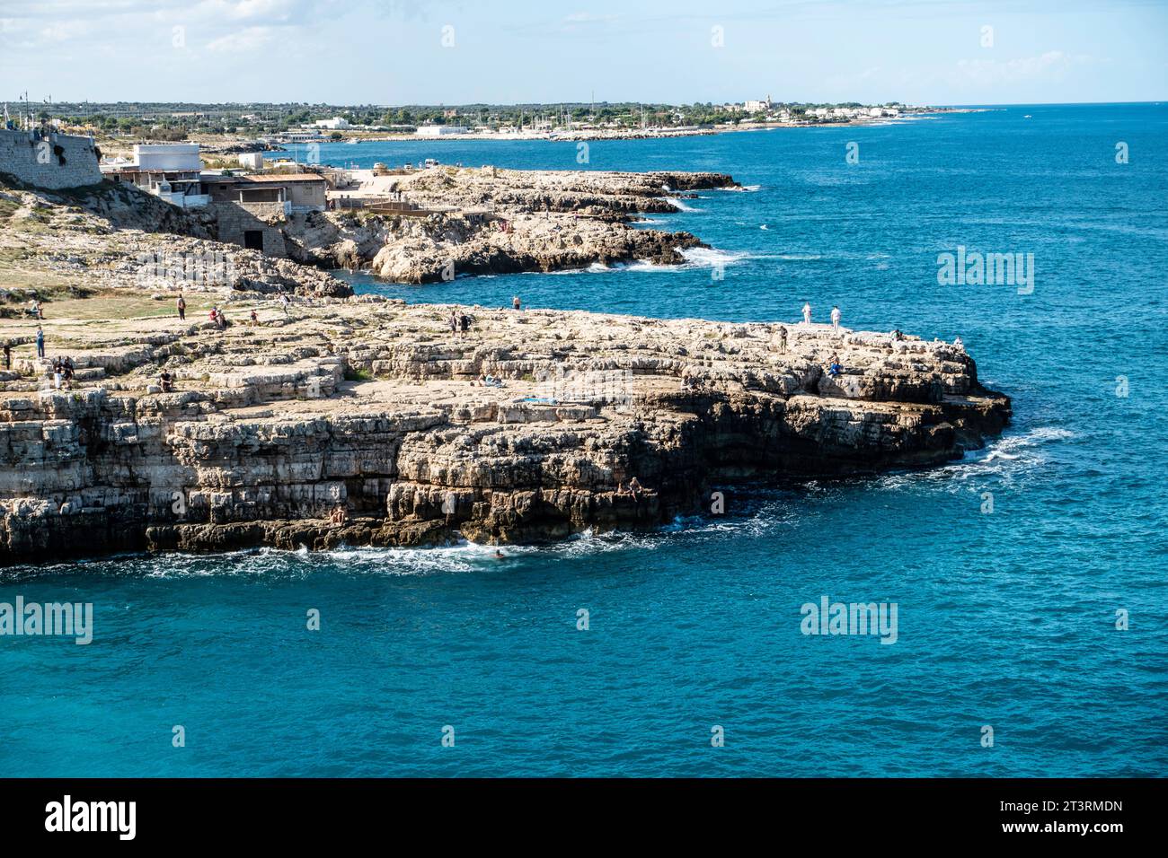 Der Felsvorsprung gegenüber dem Strand Cala Ponte in Polignano a Mare, Italien, umgeben vom kristallklaren Wasser der Adria. Stockfoto