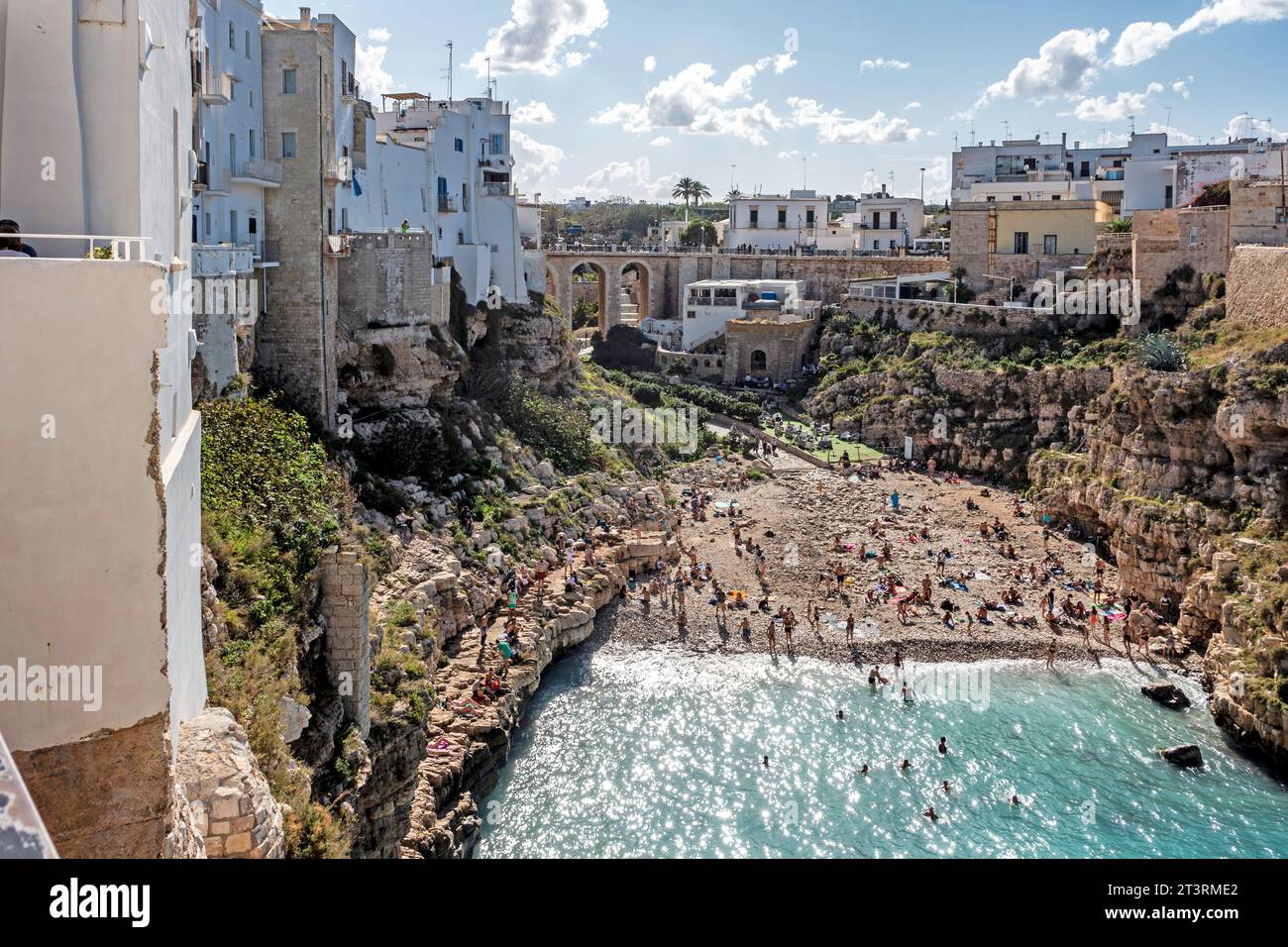 Menschen genießen den Strand Cala Ponte in Polignano a Mare, Italien, an einem sonnigen Sonntagnachmittag im Oktober. Stockfoto