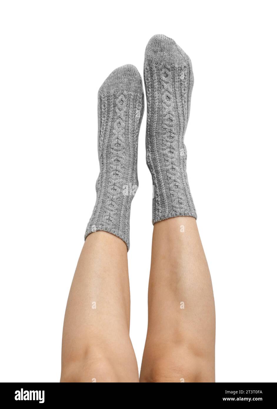 Weibliche Beine in grauen handgestrickten Wollsocken isoliert auf weißem Hintergrund, Schnittpfad inbegriffen Stockfoto