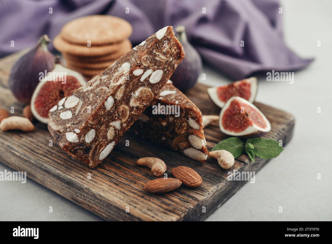 Pan de Higo: Spanisches Feigenbrot auf Holzschneidebrett mit frischen Feigen und Mandeln aus der Nähe Stockfoto