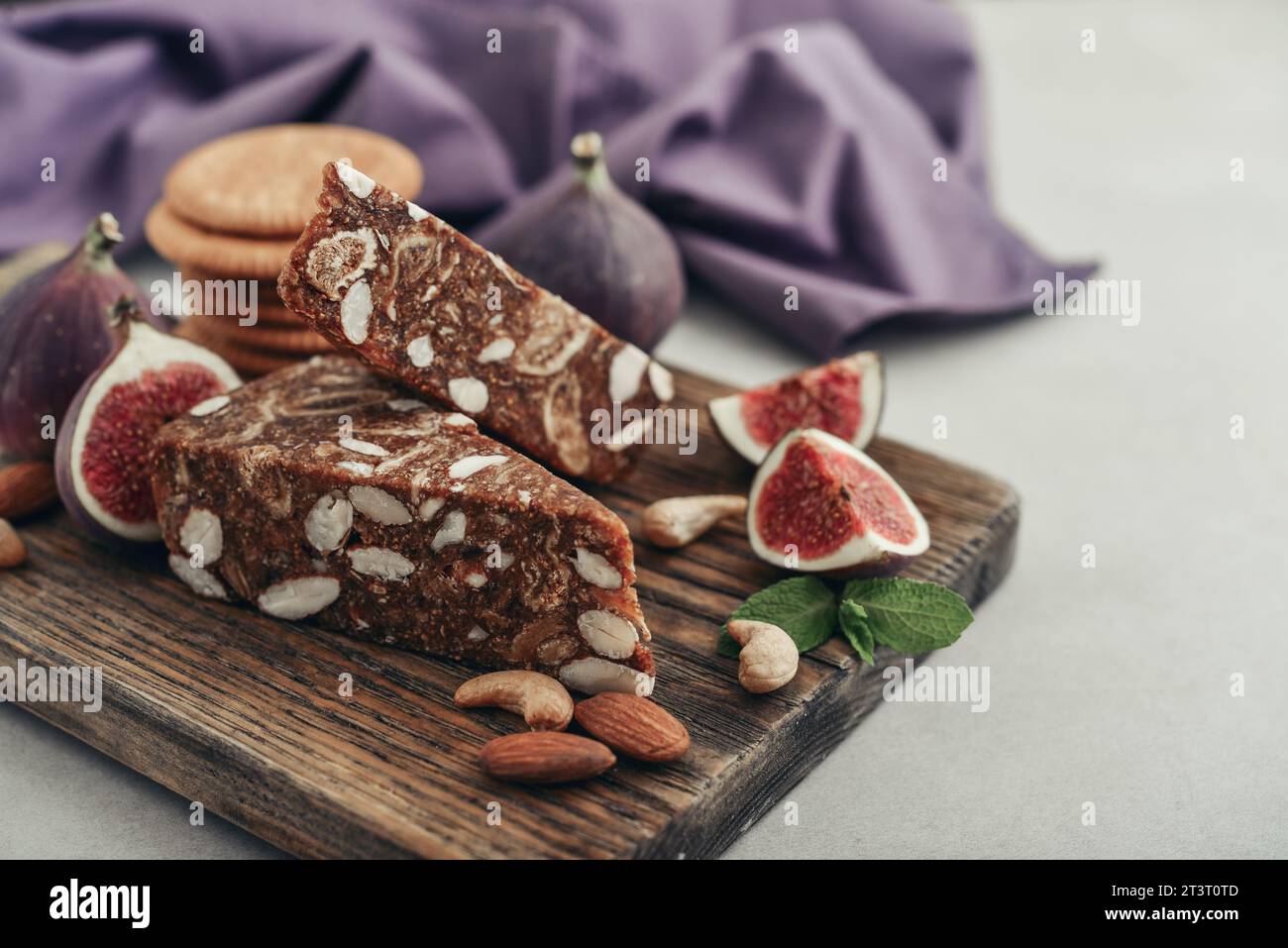 Pan de Higo: Spanisches Feigenbrot auf Holzschneidebrett mit frischen Feigen und Mandeln aus der Nähe Stockfoto
