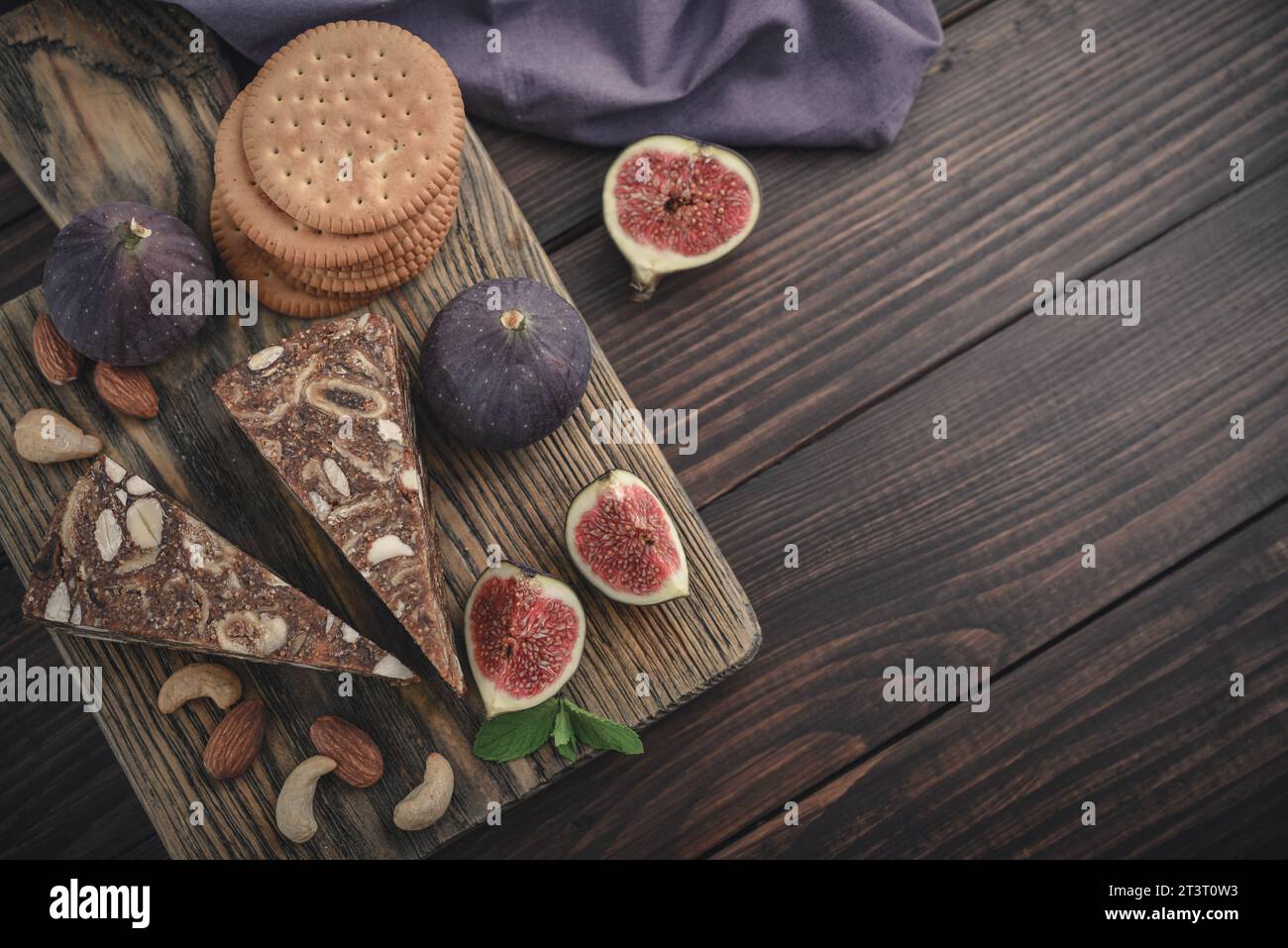 Pan de Higo: Spanisches Feigenbrot auf Holzschneidebrett mit frischen Feigen und Mandeln, Blick von oben Stockfoto