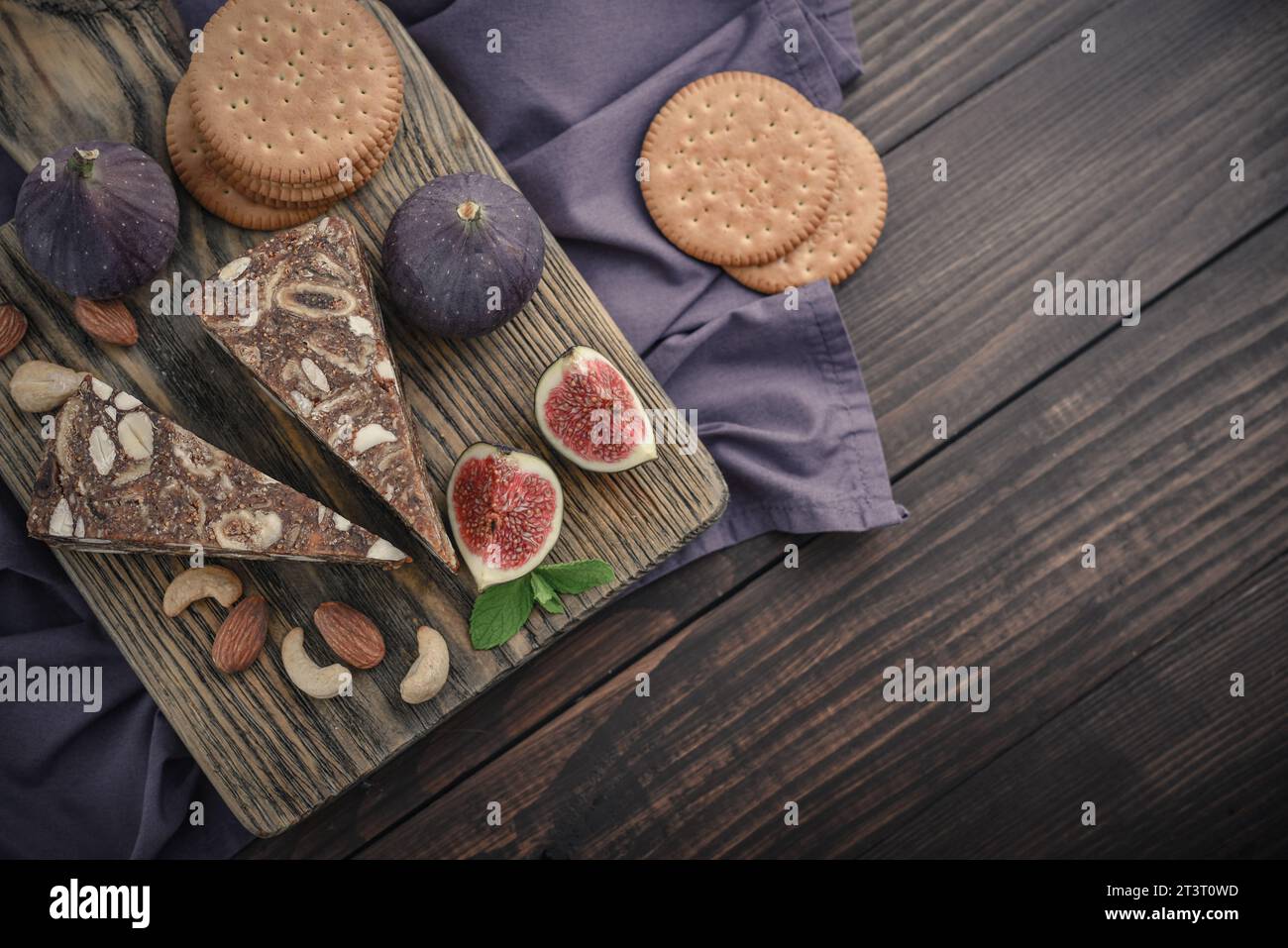 Pan de Higo: Spanisches Feigenbrot auf Holzschneidebrett mit frischen Feigen und Mandeln, Blick von oben Stockfoto