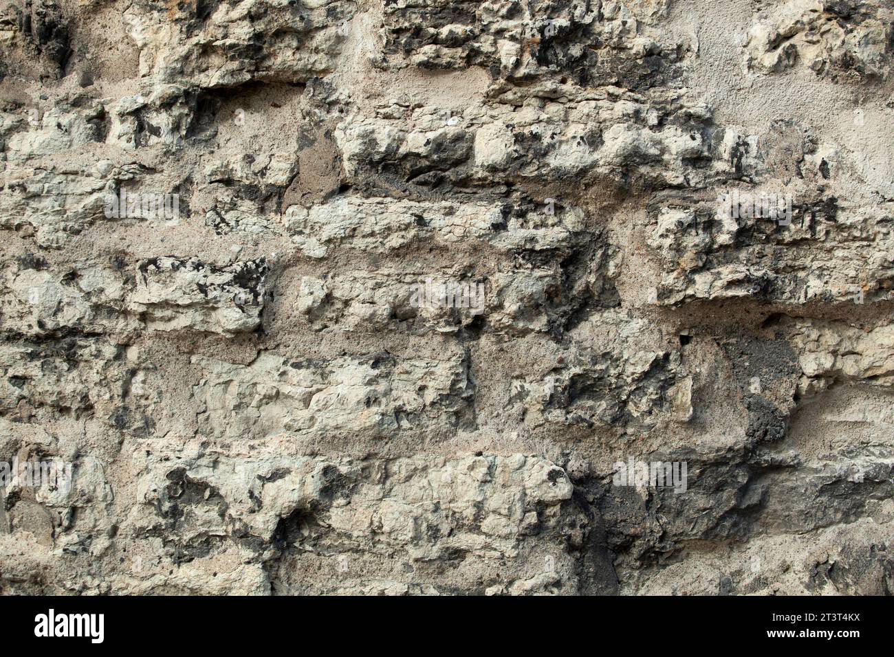 Hintergrund ungleichmäßige Betonwand in Löchern grau und hervorstehenden Steinen. Zur Dekoration. Hochwertige Fotos Stockfoto