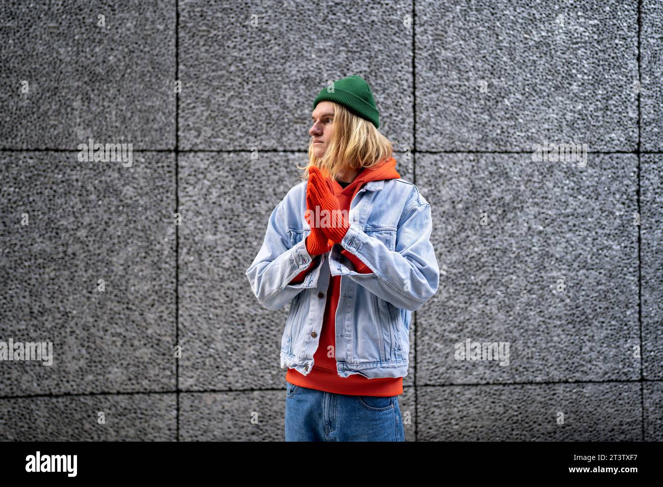 Nachdenklicher skandinavischer Slim-Guy-Hipster mit langen blonden Haaren, lgbt-Person wartet auf Freund-Treffen Stockfoto