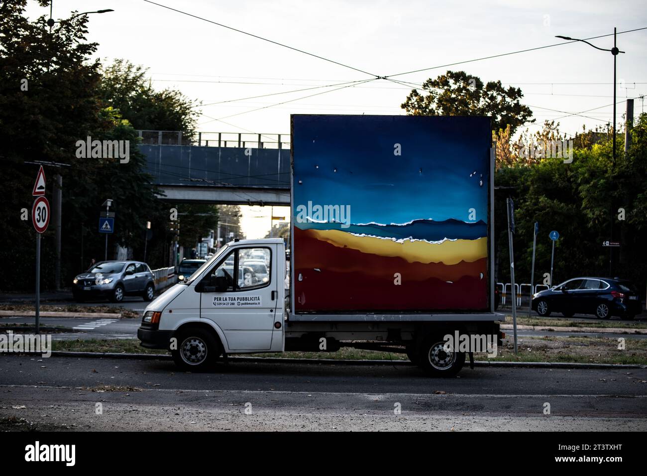 Ein imposantes Plakat ziert einen Kleinbus, dessen lebhafte Anzeige die Aufmerksamkeit auf sich zieht, während es durch die Straßen der Stadt fährt und wirkungsvolle Botschaften aussendet Stockfoto