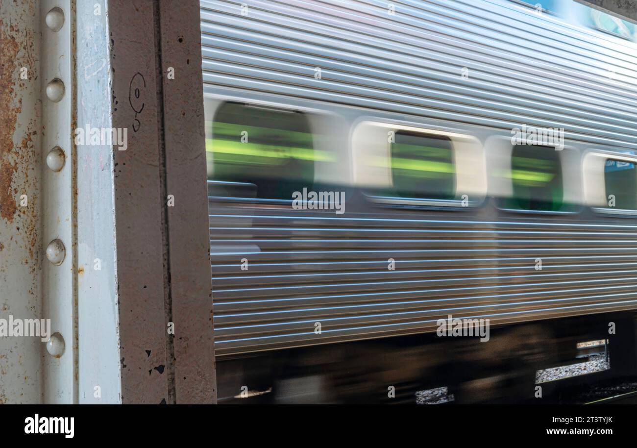 Hochauflösendes Langzeitbelichtungsbild eines sich bewegenden CTA Metra-Zuges, der durch Chicagos Bahnhöfe fährt Stockfoto