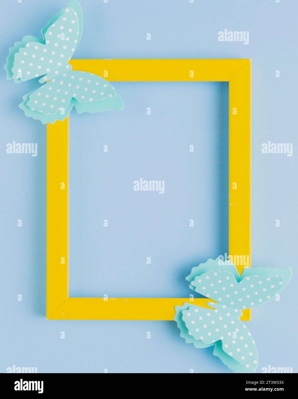 Polka gepunkteter Schmetterling gelber Rahmen blauer Hintergrund Stockfoto