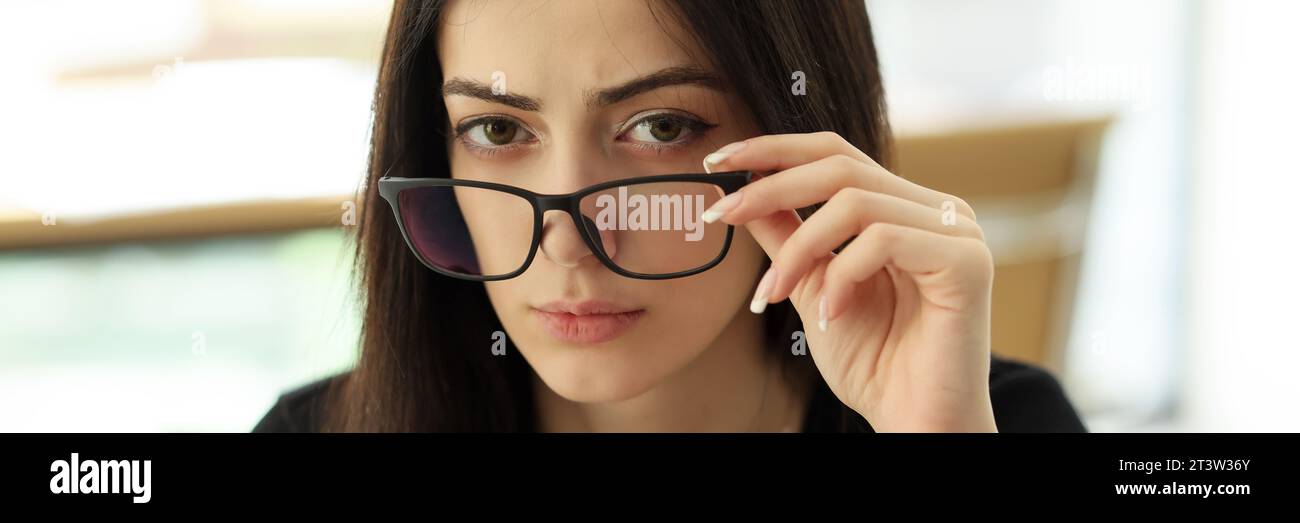 Eine seriöse Managerin entfernt die Brille und schaut in die Kamera Stockfoto