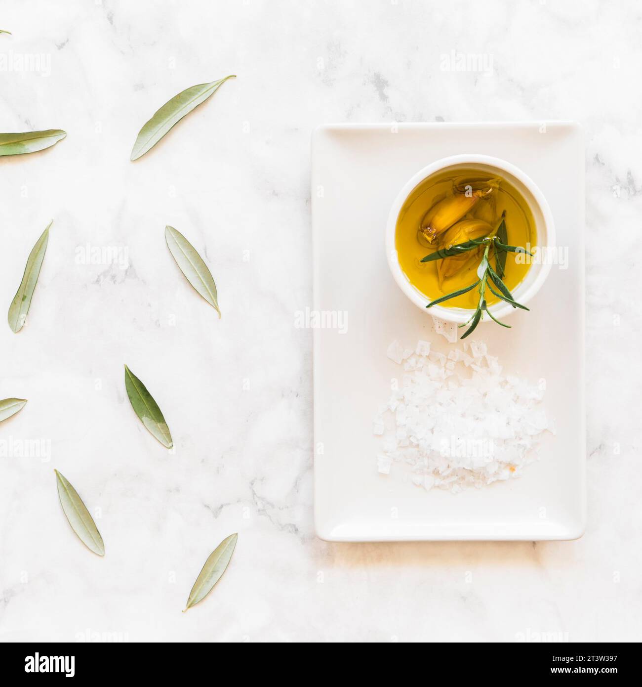 Rosmarin Knoblauchzehen Ölschale mit salzweißem Tablett Stockfoto