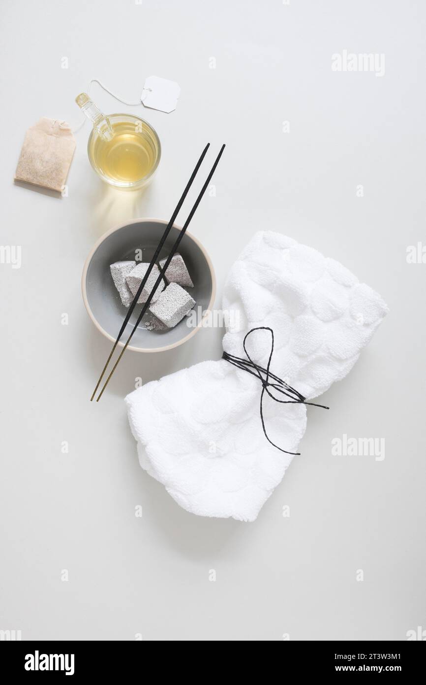 Teebeutel Öl Bimsstein Weihrauchstab gebunden Serviette weiße Oberfläche Stockfoto