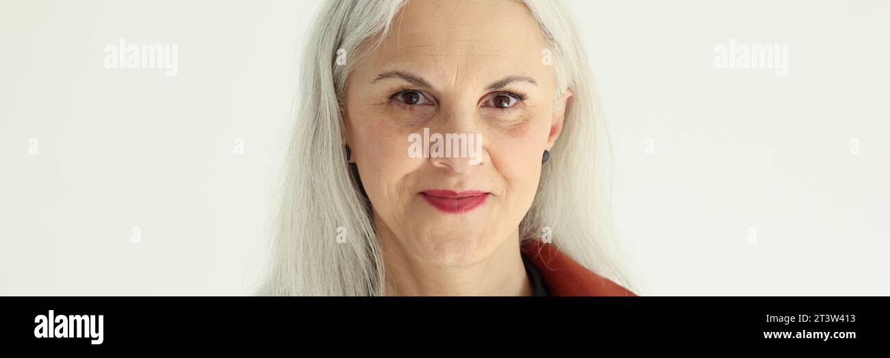 Attraktive ältere Frau mit langen grauen Haaren posiert im Studio Stockfoto