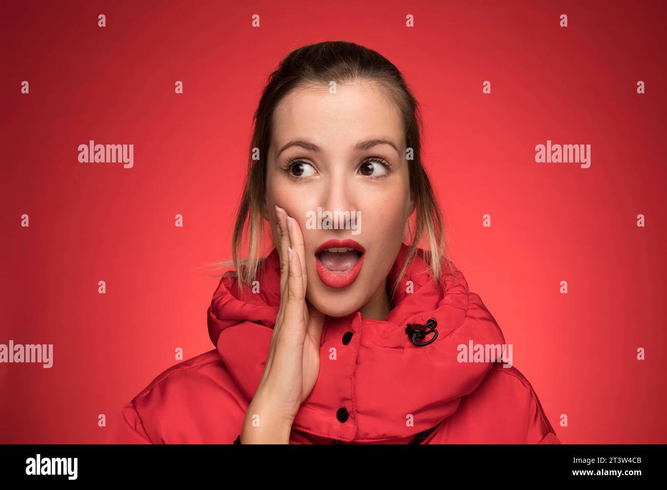 Junge Frau, roter Wintermantel schreiend Schild Stockfoto