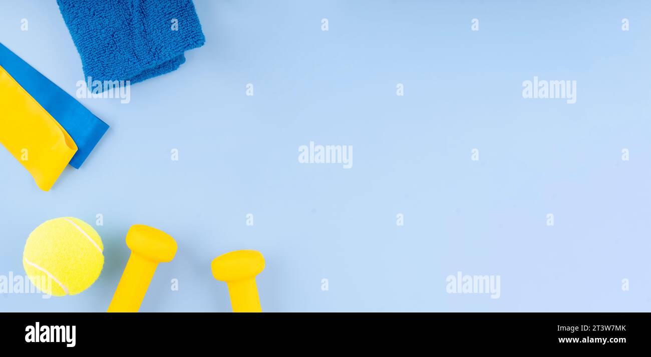 Neopren-Kurzhanteln, Fitnessbänder elastisch, Handtuch und Tennisball auf blauem Hintergrund Draufsicht, flache Lay. Fitness und gesundes Leben, Wellness-Konzept. Stockfoto