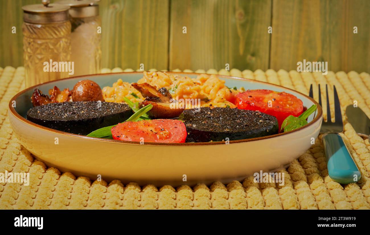 Warmes Frühstück mit Schwarzpudding und Eiern. Stockfoto