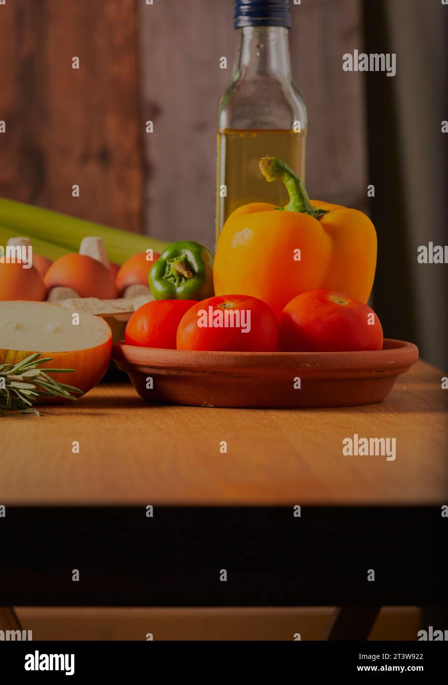 Gemischtes Gemüse mit etwas Olivenöl und frischen Eiern auf einem Küchentisch. Stockfoto