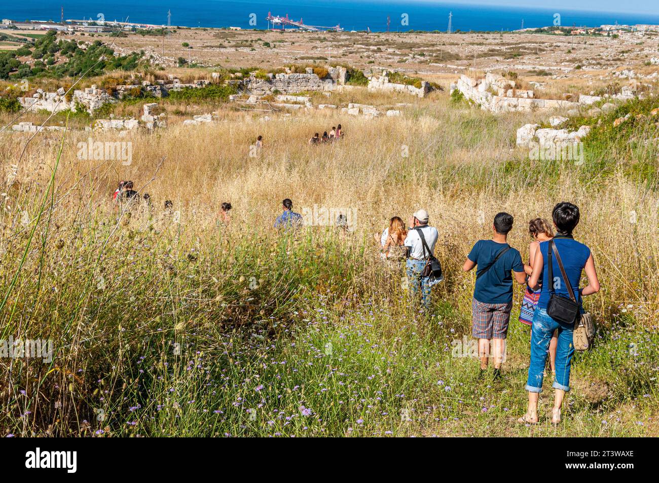 Gruppe von Touristen in einer Akte, die die Überreste einer antiken Stadt besucht Stockfoto