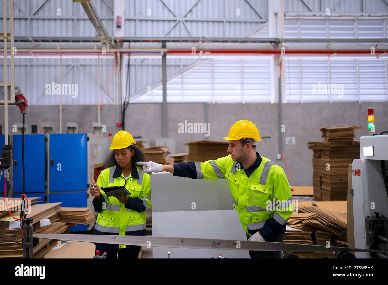 Arbeiter und Kartonverpackungsfabrik. Arbeiter und Fabrikkonzept. Stockfoto