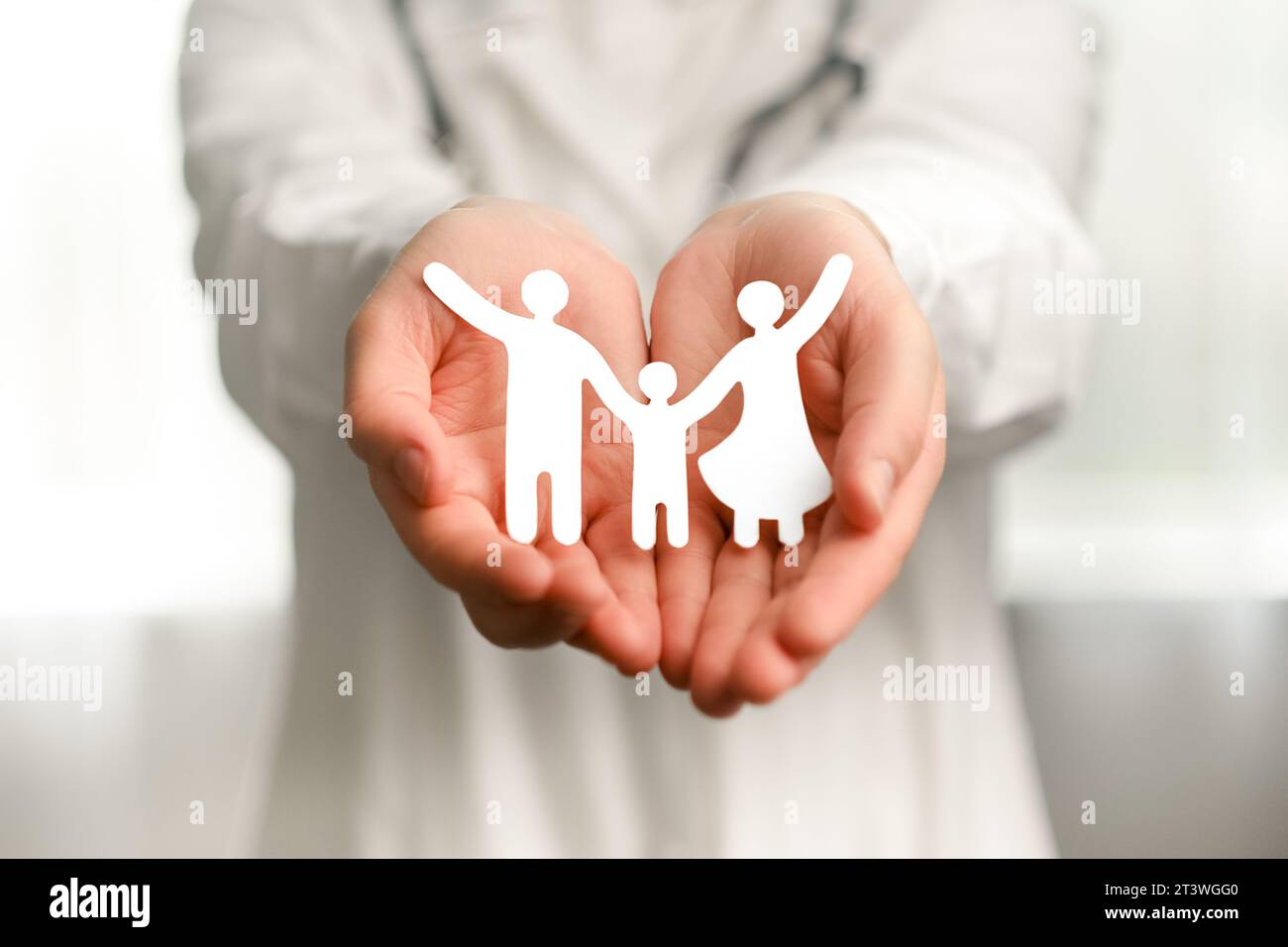 Nahaufnahme der Frau Doktor in weißer Uniform mit Stethoskop, das Papier Familienausschnitt hält Icon, Pflegepflege, Obdachlose Unterstützung, schützen, Gesundheitswesen, Welt Stockfoto