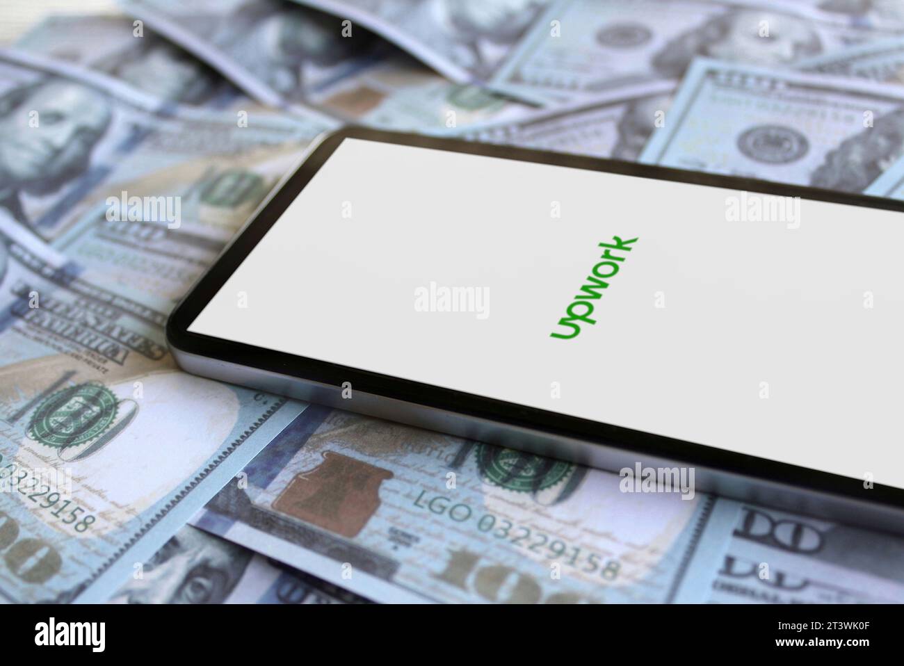 Amerikanischer Freelancing-Plattform-Service, UPWORK-App-Logo auf Smartphone und Geld. Umsatz-, Geschäfts- und Gewinnkonzept Stockfoto
