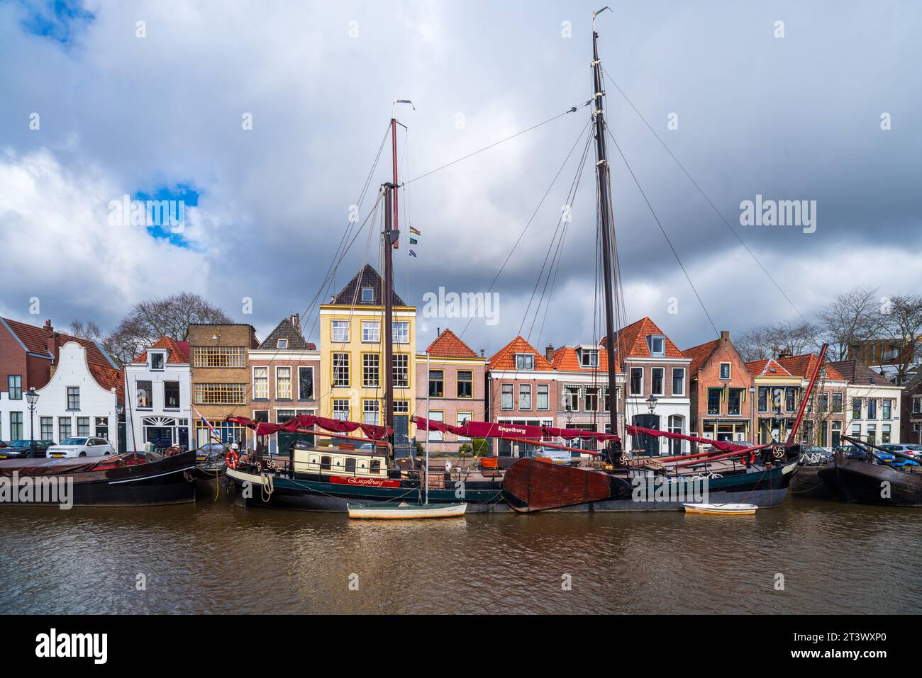 ZWOLLE, NIEDERLANDE - 14. MÄRZ 2021: Alte Boote und Lastkähne vor einigen schönen Giebelhäusern in der niederländischen Stadt Zwolle Stockfoto