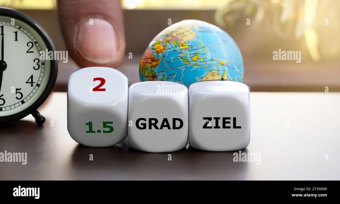 Die Hand dreht Würfel und ändert den Ausdruck „1,5 Grad ziel“ (1,5 Grad ziel) in „2 Grad ziel“ (2 Grad ziel). Stockfoto