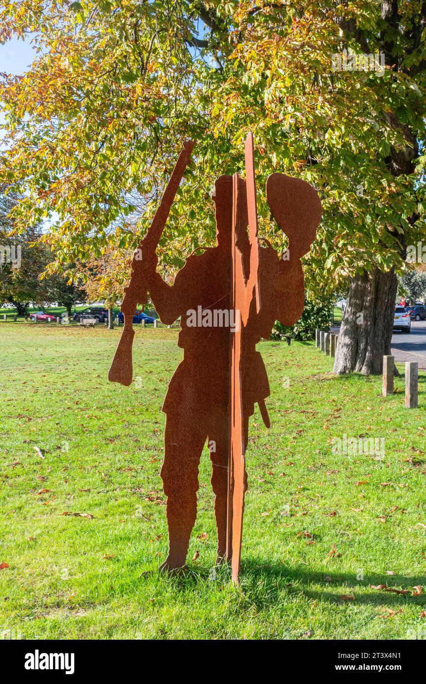 Godstone, Surrey, England, Großbritannien, das WWI Memorial auf dem Dorfgrün, Stahlskulptur bestehend aus zwei sich kreuzenden Figuren, einem Soldaten und einem Cricketspieler Stockfoto
