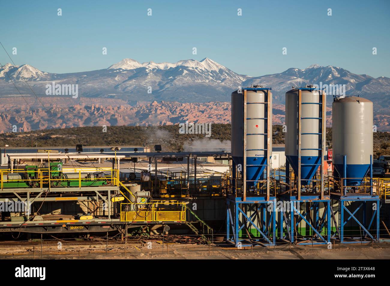 Ein Öl- und/oder Gasbetrieb mit Bergen im Hintergrund. Stockfoto