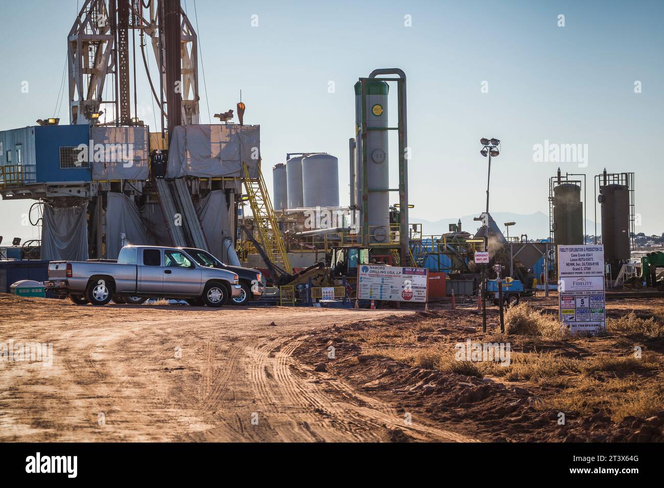 Ein Öl- und/oder Gasbetrieb mit Lkws, Schildern und Bohrgeräten. Stockfoto
