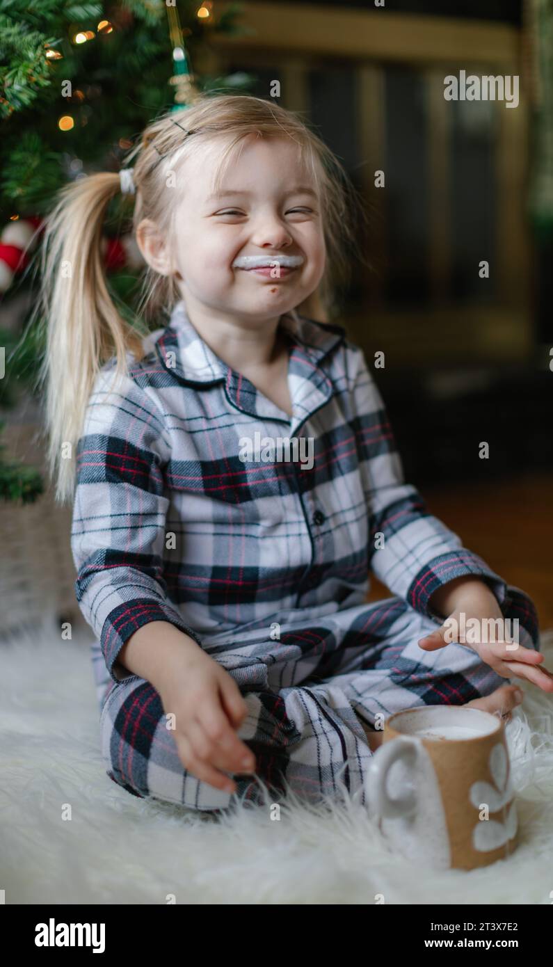 Fröhliches Kleinkind mit Kakaoschnurrbart lächelt warm in die Kamera. Stockfoto