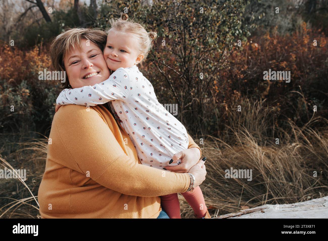 4-jähriges Mädchen umarmt Oma an einem Herbsttag Stockfoto