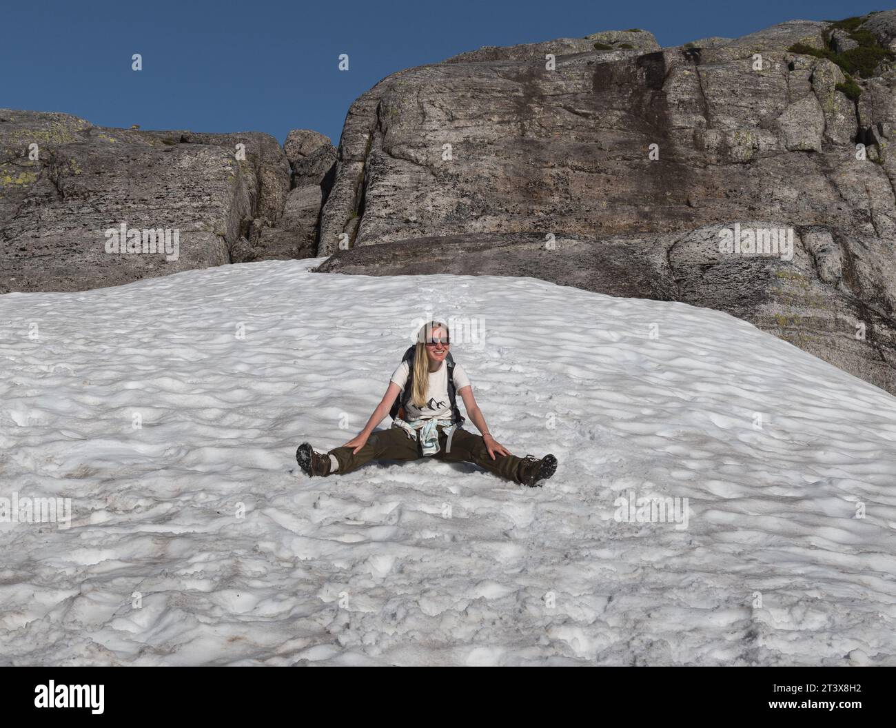 Weibliche Touristen sitzen im Schnee in den Bergen Norwegens Stockfoto