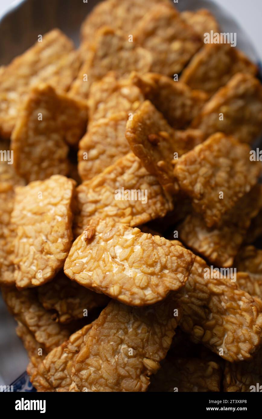 Das traditionelle indonesische Gericht „Tempeh goreng“ ist ein traditionelles indonesisches Essen, das aus fermentierten Sojabohnen hergestellt wird. Ansicht von oben nach unten (Nahaufnahme) Stockfoto
