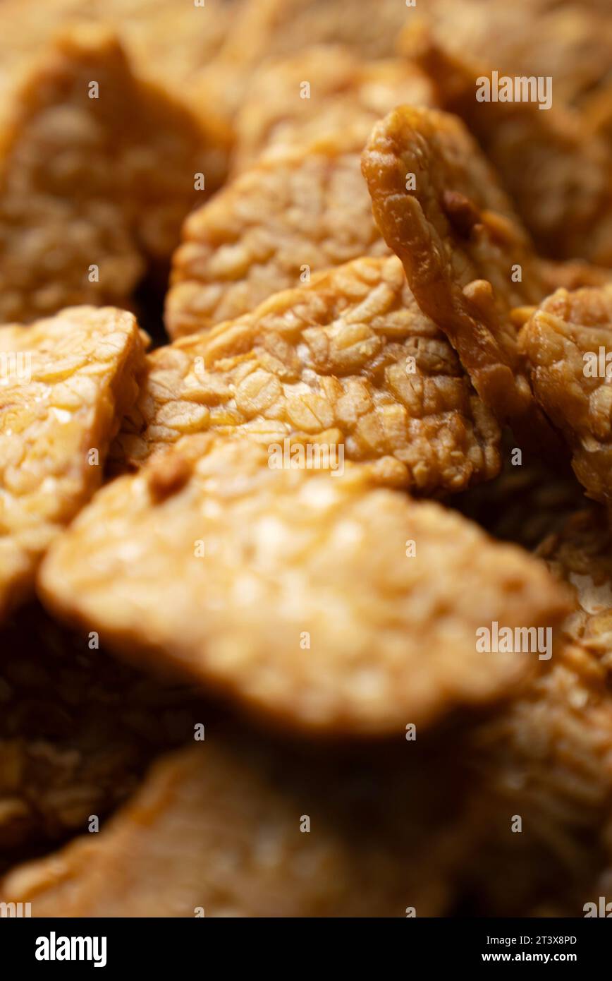 Das traditionelle indonesische Gericht „Tempeh goreng“ ist ein traditionelles indonesisches Essen, das aus fermentierten Sojabohnen hergestellt wird. Ansicht von oben nach unten (Nahaufnahme) Stockfoto