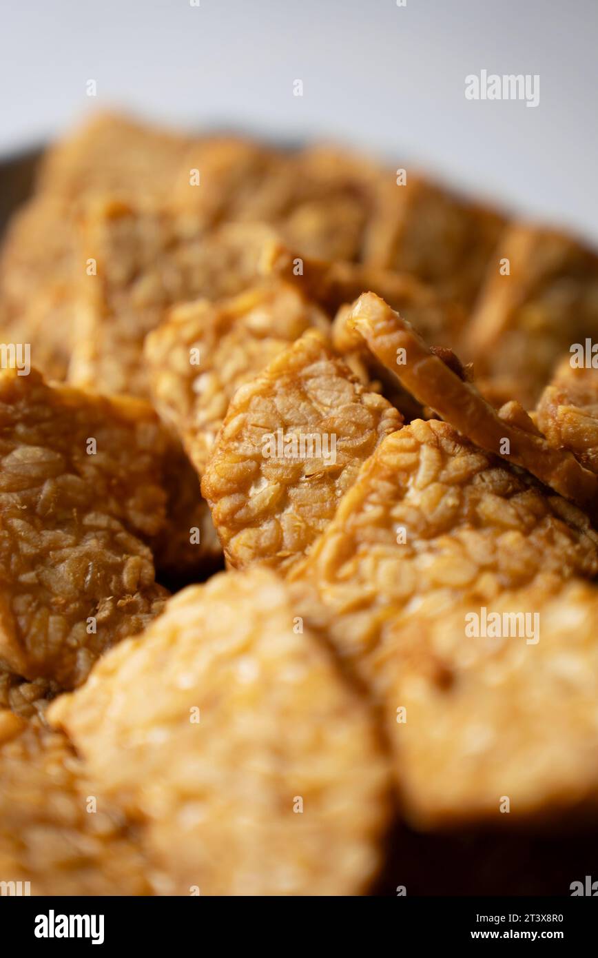 Das traditionelle indonesische Gericht „Tempeh goreng“ ist ein traditionelles indonesisches Essen, das aus fermentierten Sojabohnen hergestellt wird. Ansicht von oben nach unten (Nahaufnahme) Stockfoto