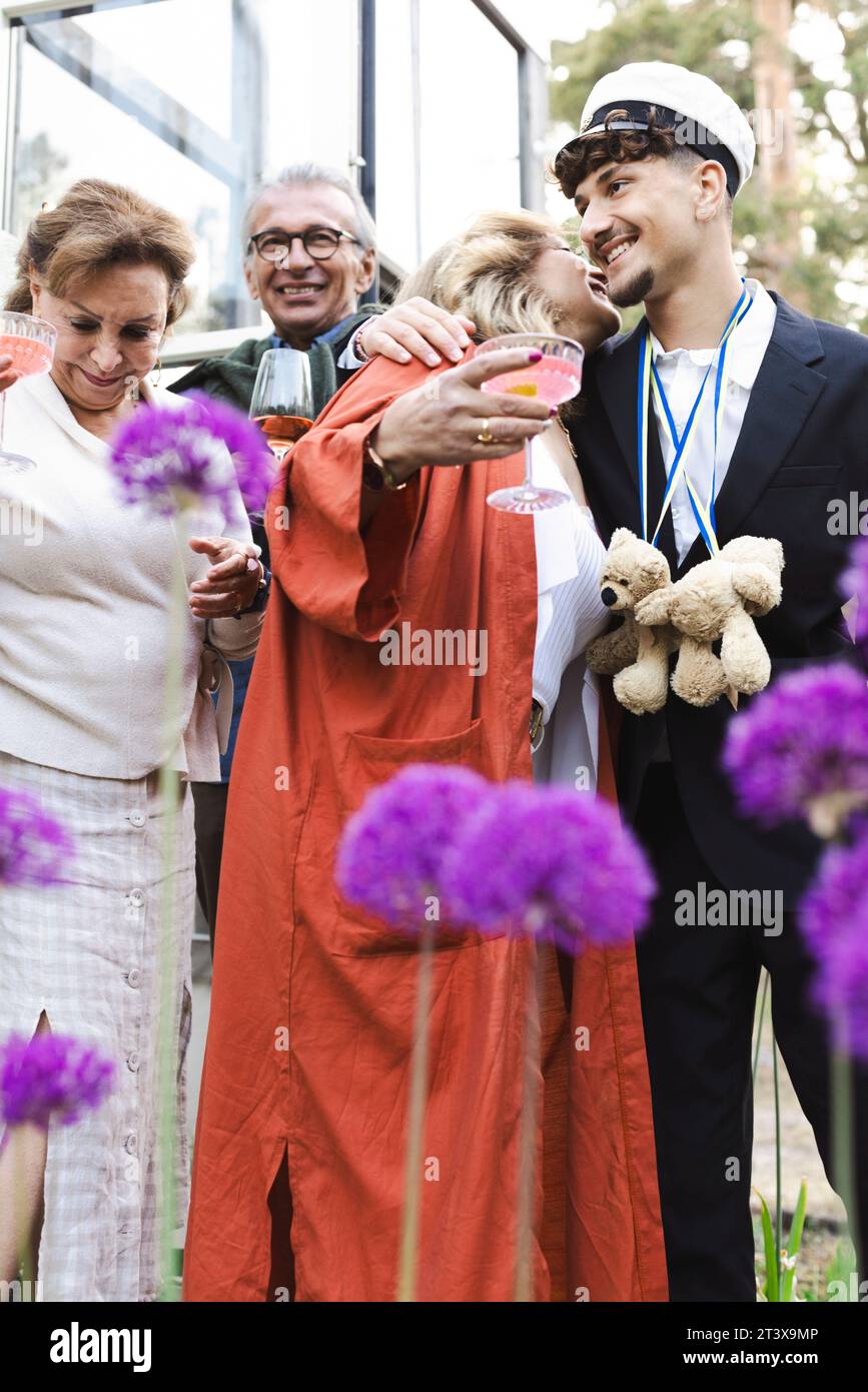 Lächelnde Männer und Frauen genießen die Sommerparty im Hinterhof Stockfoto