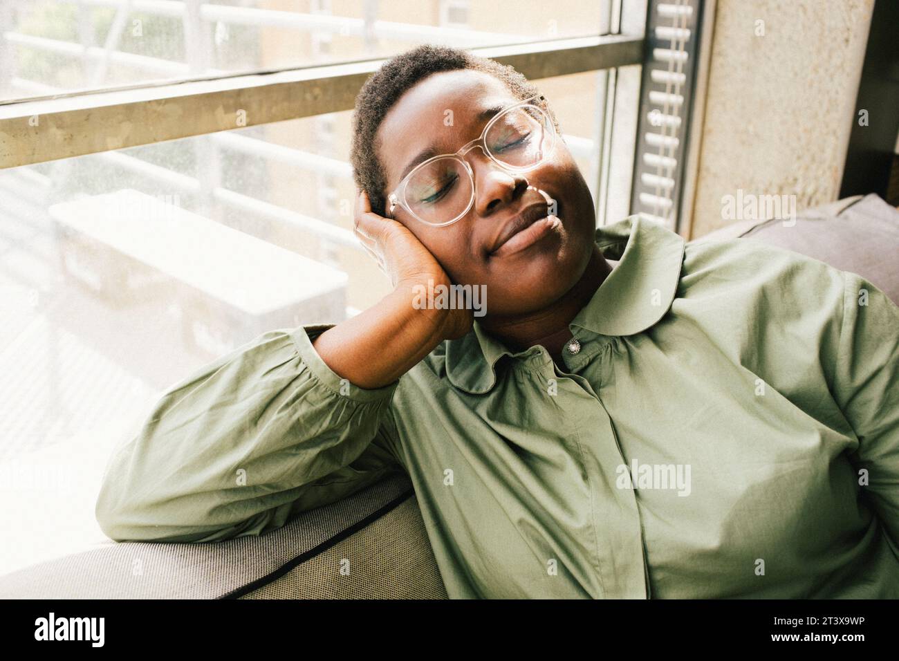 Geschäftsfrauentag träumt, während sie am Fenster im Büro sitzen Stockfoto