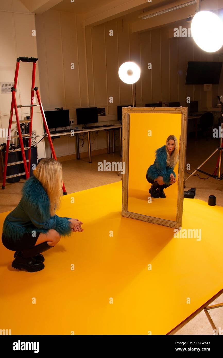 Machen Sie Fotos im Studio mit gelber Wand und einer Schönheitsscheibe mit Lichtauflage Stockfoto