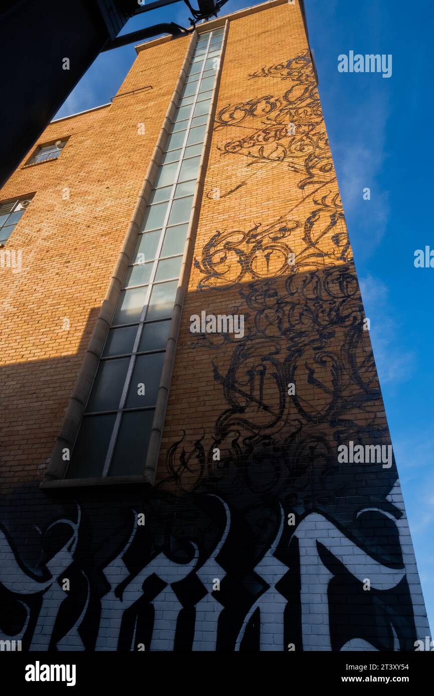 Eine urbane Straßenszene mit einem mit Graffiti bedeckten Gebäude aus einem niedrigen Winkel Stockfoto